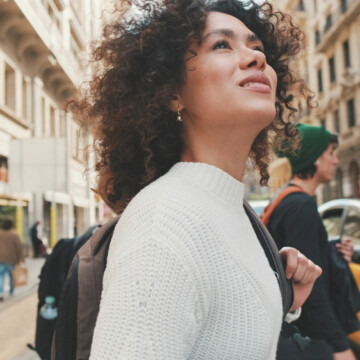 A young African American female with bouncy curls styled with a combination of leave-in cream and a hydrating leave-in conditioner.