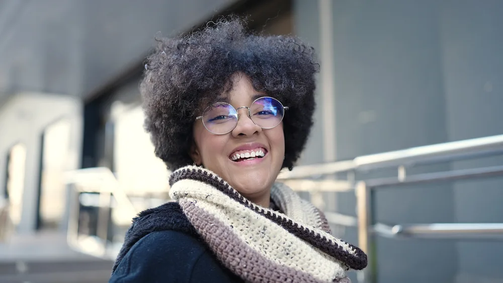 With a touch of coconut oil, her curly hairdo radiates a natural shine and moisture, showing the transformative power of organic hair products.