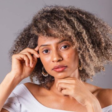 A black girl with thick hair was cleaned with a soap nut liquid natural shampoo and styled with essential oils, like a lavender essential oil.