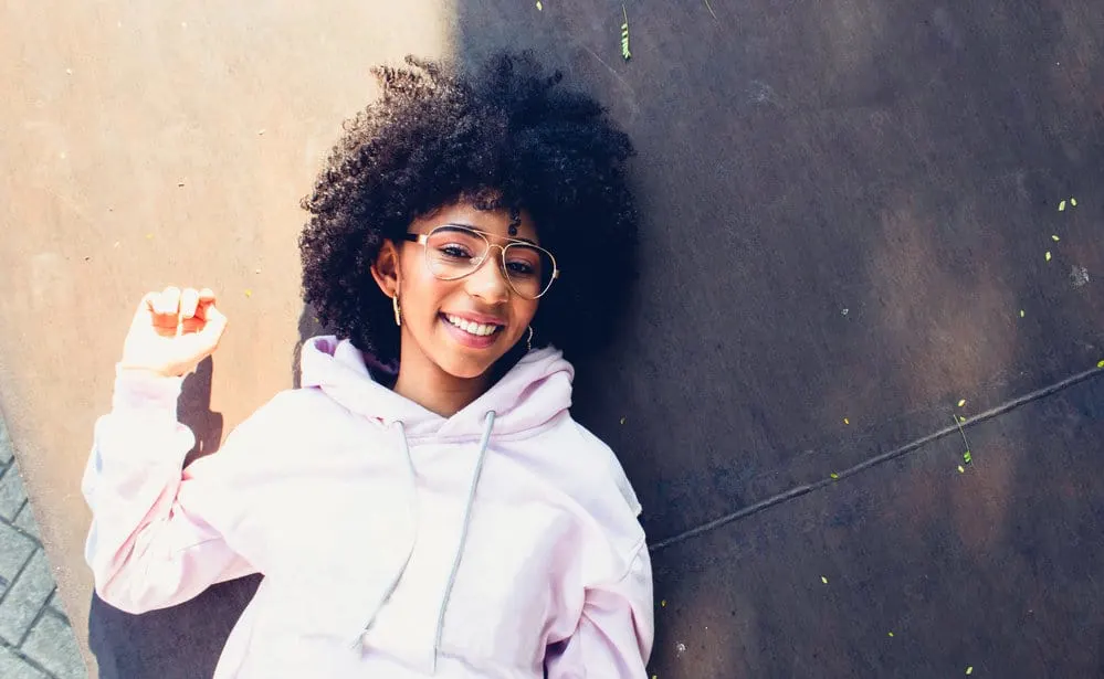 This cute black girl with light-brown skin rocks her natural curly hair, showcasing gorgeous bouncy curls that exude confidence and style.