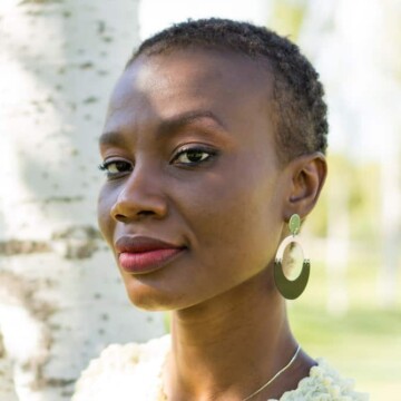 An African American woman with thin hair wearing one of the most popular short haircuts for women that highlights her natural curls.