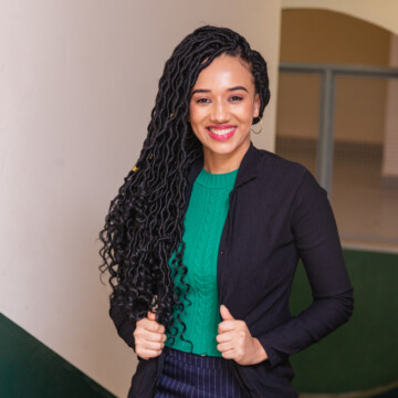 A young black woman wearing micro braids that are all the rage in the natural hair community due to their modern take on a braided hairstyle.