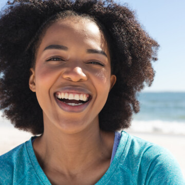 A beautiful black female with dark brown color-treated hair strands styled with coconut oil and avocado oil after a clarifying session followed by a deep conditioning mask.