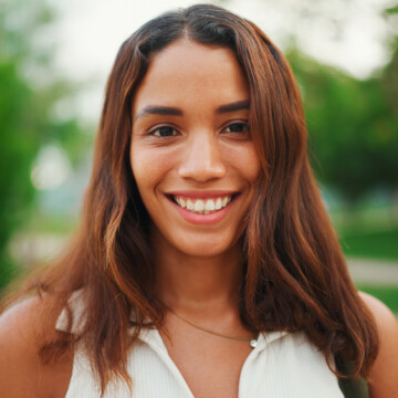 A beautiful girl with orange hair with cool tones that include hints of her dark brown natural hair color. The color matches perfectly with her brassy yellow tones.