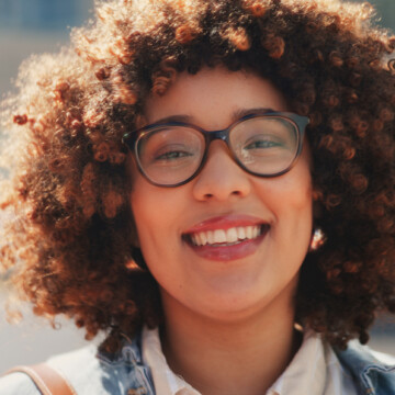 A cute African American female with dry hair styled with essential oils, like Jamaican castor oil and sunflower oil.