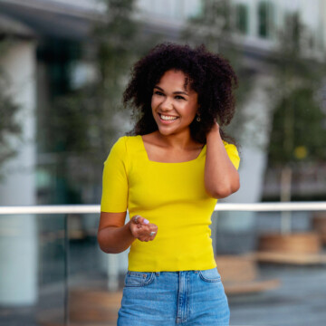 A cute black girl with beachy waves styled with dry texture spray on damp hair to create natural volume and soft texture.